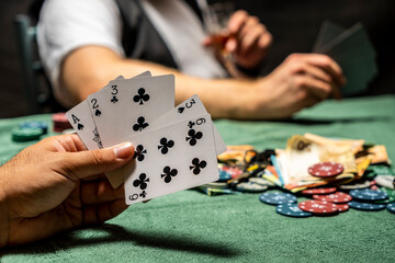 poker players on green table with real chips and money