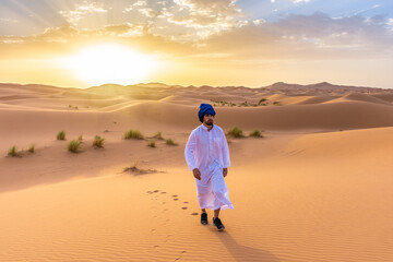 Berber man wearing traditional clothes in the Sahara Desert at dawn, Morocco