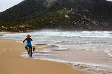 person riding a bike on the beach