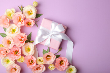 flower arrangement and gift on colored background top view with place for text