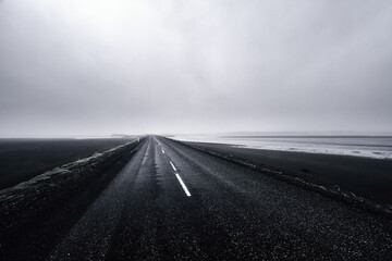 Misty coastal road through desolate landscape in Iceland
