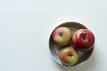 ripe crab apples contained within a metal lid on white