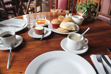 Delicious Mexican breakfast with coffee, sweet bread, beans, chilaquiles, butter, jam, sugar, fried egg, omelette
