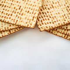 Ritual Jewish bread-matzah on a white background. The symbol of the celebration of the traditional spring holiday - Judean Passover. High angle view.There is an empty space for insertion.