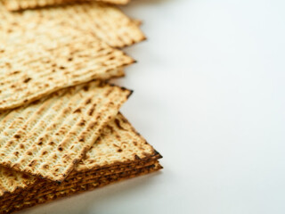 Traditional Jewish bread - matzah. White simple background. High angle view. Celebration of Jewish Passover, kosher dish, religion, Judaism, traditions, rituals.