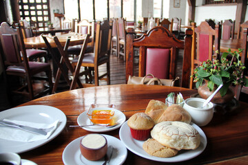 Delicious Mexican breakfast with coffee, sweet bread, beans, chilaquiles, butter, jam, sugar, fried egg, omelette
