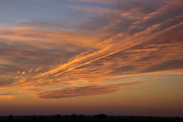 A wide shot of a dramatic orange and blue sunset or sunrise sky