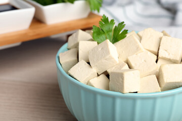Delicious tofu with parsley in bowl on table, closeup