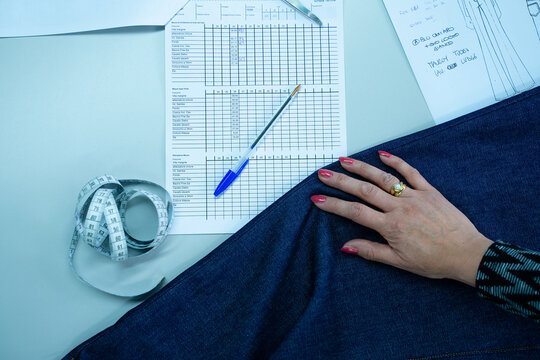 Italian Seamstress Working With Meterstick, Paper Document, Denim Fabric