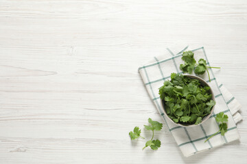 Fresh aromatic cilantro on white wooden table, flat lay. Space for text