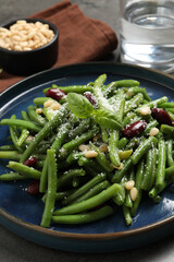 Plate of tasty salad with green beans on grey table