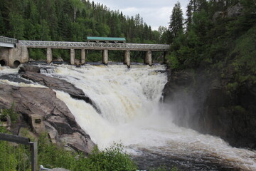 Fototapeta na wymiar waterfall in the mountains with a bridge