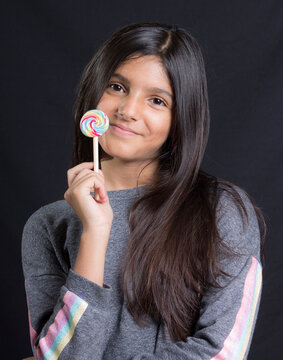 portrait of latin girl smiling with a candy in hand
