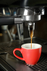 Making fresh aromatic espresso using professional coffee machine