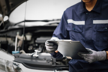 Hand of car mechanic with wrench. Auto repair garage. mechanic works on the engine of the car in the garage. Repair service. Concept of car inspection service and car repair service.