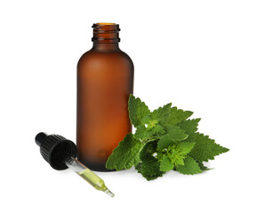Glass bottle of nettle oil with dropper and leaves isolated on white