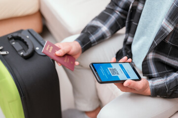 Vaccinated person using digital health passport app in mobile phone for travel during covid-19 pandemic. blue certificate