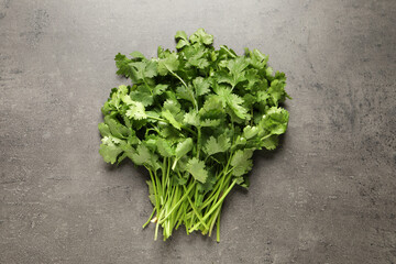 Bunch of fresh green cilantro on grey table, top view