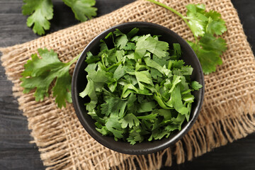 Cut fresh green cilantro on black table, flat lay