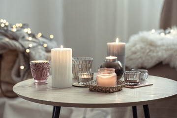Beautiful candles in the Scandinavian style on a blurred background with bokeh.
