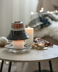 Cozy composition with burning candles on a blurred background with bokeh.