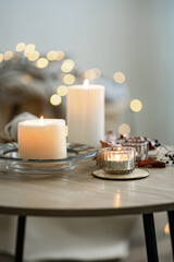 Cozy home composition with candles on blurred bokeh background.