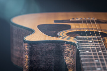 Close-up of a classical acoustic guitar in beautiful lighting. - obrazy, fototapety, plakaty
