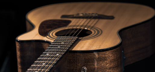 Fototapeta premium Close-up of a classical acoustic guitar on a black background.