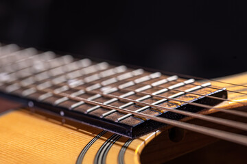 Fototapeta premium Close-up of a guitar fretboard on a black background.