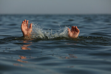Drowning man reaching for help in sea