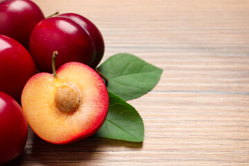 Naklejka na ściany i meble Fresh ripe cherry plums on wooden table, closeup