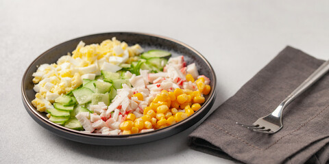 Salad of crab sticks, cucumbers, eggs and corn. Russian festive food