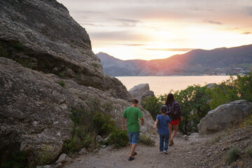 Fototapeta premium People walking in the mountains at sunset