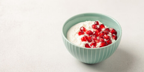 Cottage cheese with pomegranate grains in a bowl on the table. Healthy breakfast