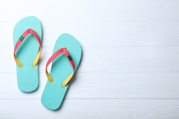 Stylish flip flops on white wooden background, flat lay. Space for text