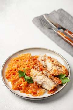 Fish pollock fillet with garnish stewed cabbage in a plate on the table. Healthy diet