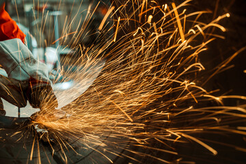 Highly skilled workers wearing industrial uniforms and Welded Iron Mask at Steel use electric wheel grinding on steel structure in the construction industrial factory.industrial safety first concept