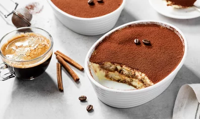 Fotobehang Classic Italian Dessert Tiramisu topped with cocoa  in a ceramic dish. Light gray background. © Nelea Reazanteva