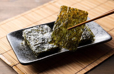 Korean seaweed on a wooden table. Asian food. - obrazy, fototapety, plakaty