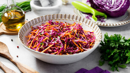 Fresh red cabbage salad with carrot, diet food. Light gray background.