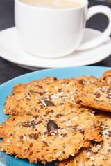 Cup of coffee with milk and fresh baked healthy oatmeal cookies. Delicious crunchy dessert