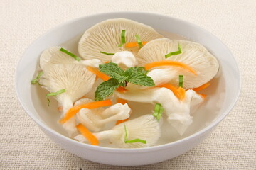 Organic mushroom soup served in ceramic bowl, traditional recipes background.