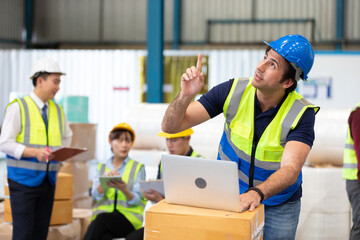 engineer or factory worker using laptop computer, talking and pointing up to something