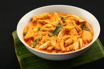 Delicious homemade  anchovy fish curry with coconut and green mangoes - Asian seafood recipes background.