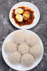 South Indian cuisine- homemade steamed rice hoppers, idiyappam with spicy egg roast curry. 