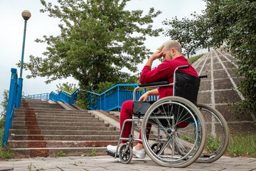 A man sits in a wheelchair, faced with difficulties alone, depression. The concept of a wheelchair, disabled person, full life, paralyzed, disabled person, health care.