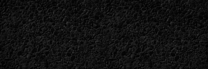 Fototapeta premium Black stone texture. Pebbles. Dark rock background with copy space for design. Wide banner.