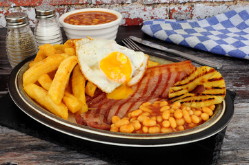 Grilled gammon egg and chips meal with baked beans and pineapple fruit ring