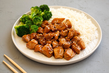 Homemade Teriyaki Chicken with Rice and Broccoli on a plate on a gray background, side view.