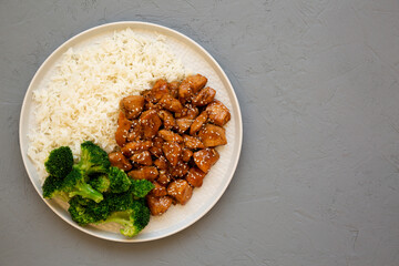 Homemade Teriyaki Chicken with Rice and Broccoli on a plate on a gray surface, top view. Flat lay, overhead, from above.